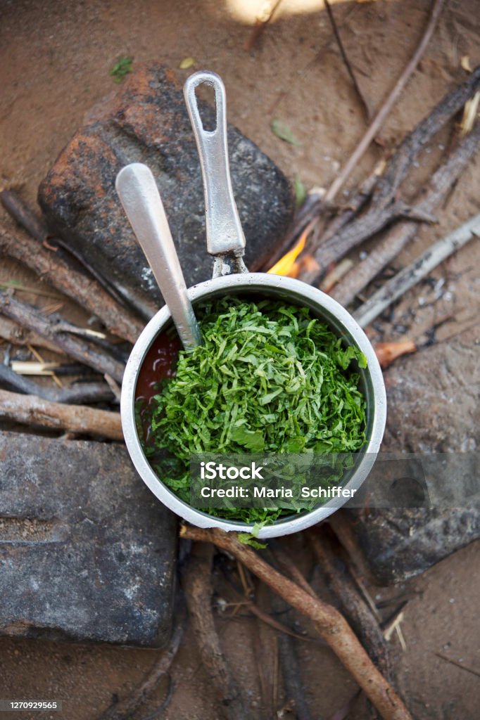 Cooking in Africa Cooking greens over an open fire in Malawi. Africa Stock Photo