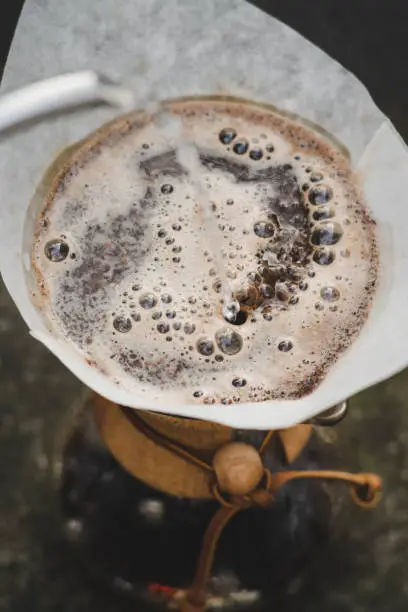 top down portrait shot of water pouring into bubbling coffee grounds filter coffee process