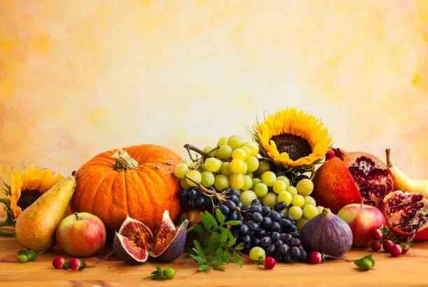 Autumn concept with flowers,pumpkin and seasonal fruits