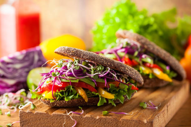 istock Vegan burger or sandwiches with rye bread, different vegetables and sprouts. 1270939375