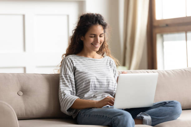 istock Woman sit on couch put notebook on laps texting email 1270939950
