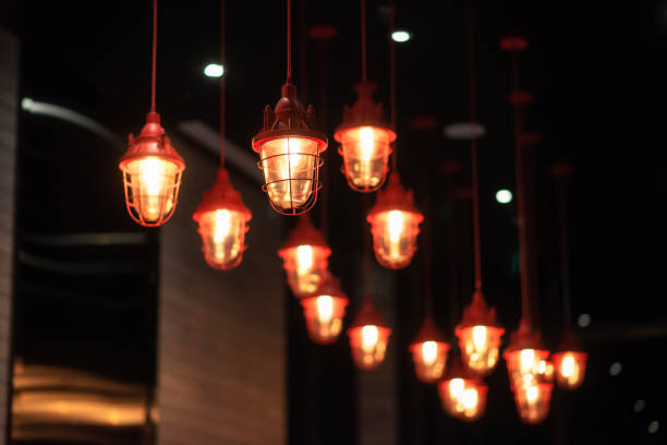 Chinese red metal chandeliers hang from the ceiling of luxury hotel, many lamps. Interior decoration.