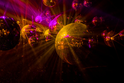 mirror balls with glowing purple and gold rays