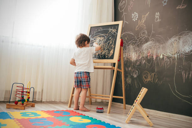 istock Toddler boy drawing on the chalk board 1270942353