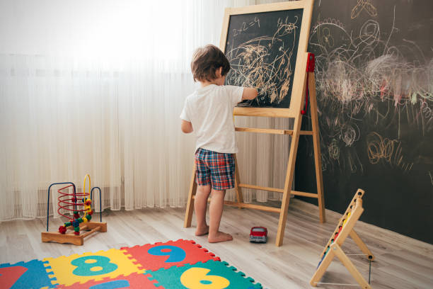 istock Toddler boy drawing on the chalk board 1270942656
