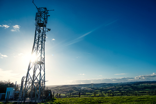 A large mobile phone mast on a sunny evening and clear blue sky