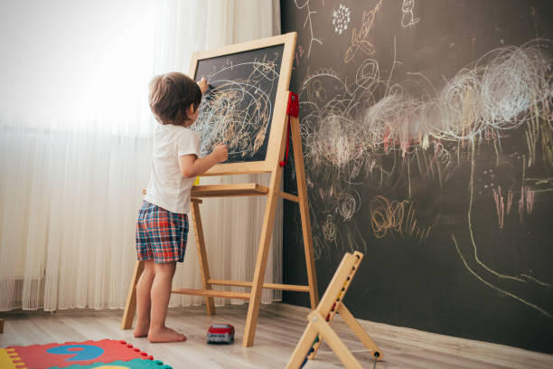 istock Toddler boy drawing on the chalk board 1270943949