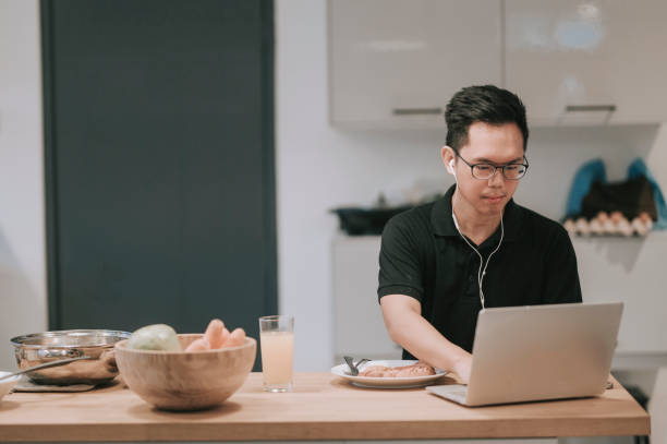 istock An asian chinese mid adult having breakfast in dining room while using laptop to reply emails 1270944399