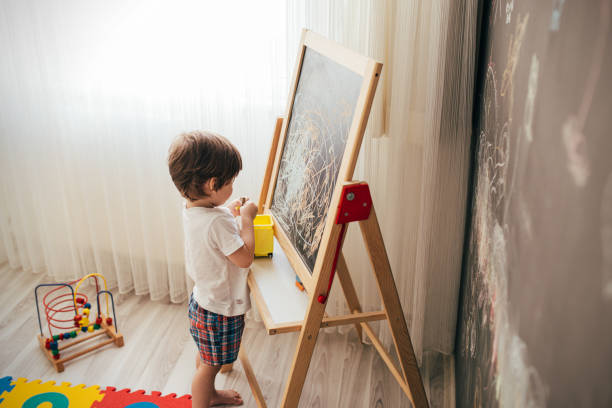istock Toddler boy drawing on the chalk board 1270944445