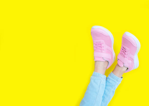 istock pink sneakers and blue jeans on a yellow background. Mockup. Copy space 1270944637
