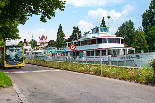 a public bus with the number 1 to Gwatt Deltapark, a canal-lying ferry with the name Beatus, and in the background Thun Castle. City of Thun, Canton of Bern, Switzerland, Europe