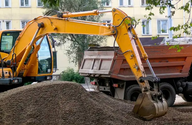 a digger scoops a bucket of gravel