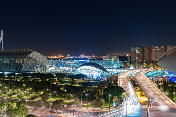 panorama de nuit de la ville des arts et des sciences à valence avec une grande illumination et des pistes lumineuses de voitures de passage - valencia province valencia european culture ciutat de les arts i les ciencies photos et images de collection