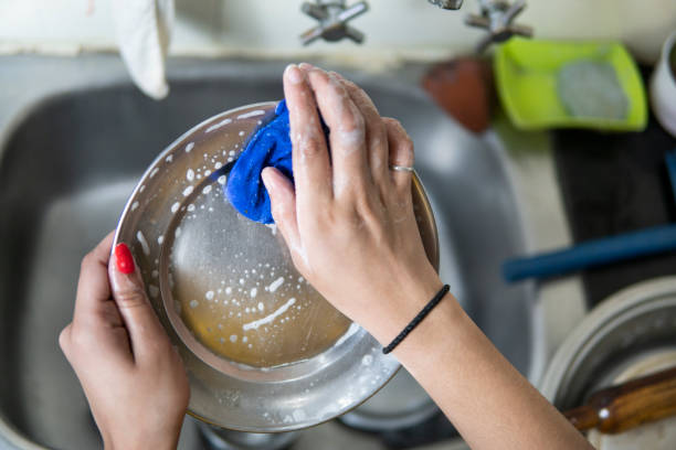 istock Close-up woman's hand washing dishes over kitchen sink. 1270954849
