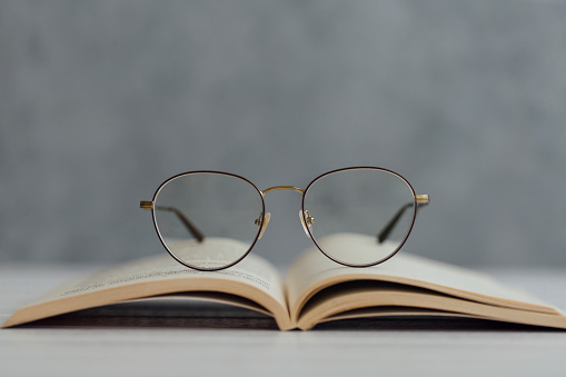 Close-up of eyeglasses over a book on table