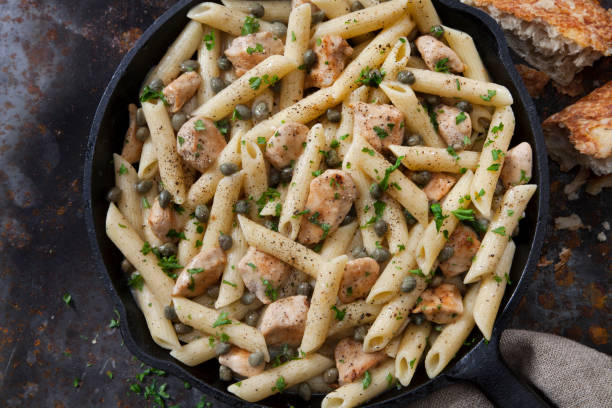 Grilled Chicken Piccata with Penne Pasta and Fresh Artisan Bread Grilled Chicken Piccata with Penne Pasta and Fresh Artisan Bread chicken rigatoni stock pictures, royalty-free photos & images