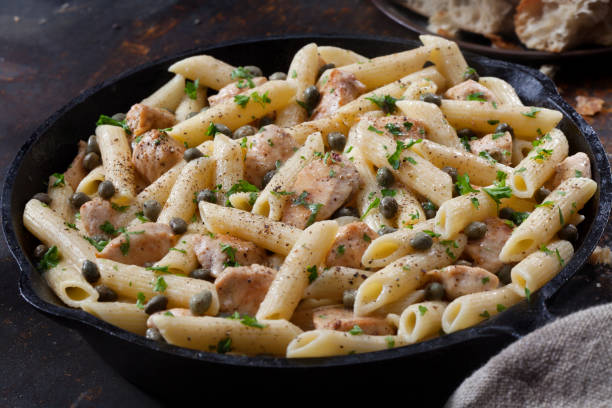 grilled chicken piccata with penne pasta and fresh artisan bread - penne imagens e fotografias de stock