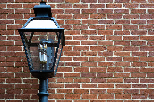 Outdoor lamp on an Old repaired weathered redd brick wall for background, Brick wall. Brick wall texture. brick wall background. bricks wall pattern. Texture brick wall of beige color. Brick pattern, Background of brick. Orange brick. Antique brickwork. Restoration.