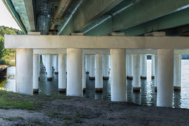 istock White oncrete bridge supports across the river. Under a bridge. 1270960791