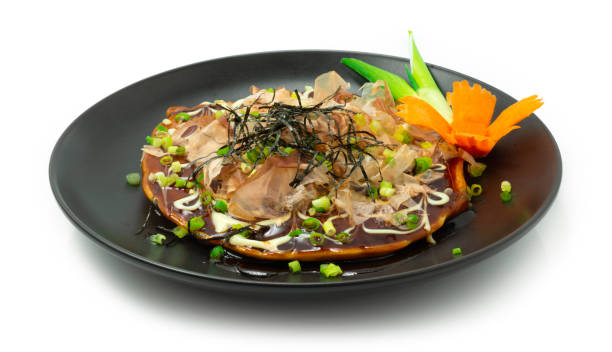 Okonomiyaki ontop Kutsuobushi & spring onion savory version of Japanese pancake stock photo