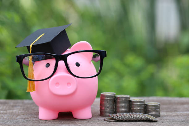 Graduation hat on pink piggy bank with stack of coins money on nature green background, Saving money for education concept Graduation hat on pink piggy bank with stack of coins money on nature green background, Saving money for education concept scholarship stock pictures, royalty-free photos & images