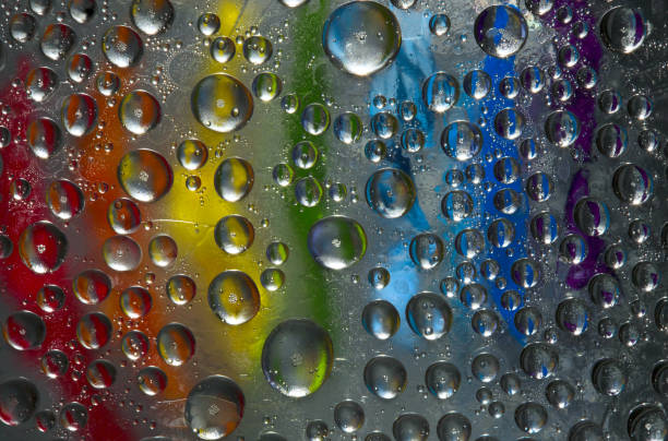 istock Rounded ice particles are located on the mirror ice surface against the background covered with rainbow-colored paints. Abstract fantasy. 1270962899