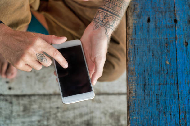 istock Female digital nomad with tattooed arms using smart phone above pov 1270964539
