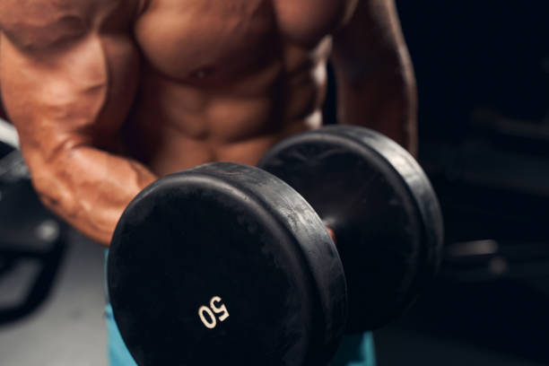 istock Athletic young man exercising with dumbbells at the gym 1270964886