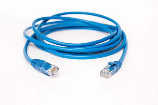 Blue patchcord with RJ45 plug lan network isolated on white background.