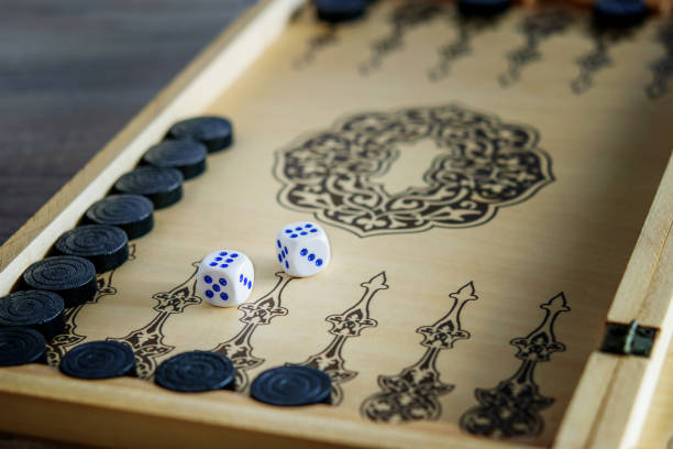 Rolling two dice on a wooden desk. Gambling dices falling. Dices set to play backgammon. Back gammon table game. Play this ancient Turkish and Persian table game with strategy and luck.