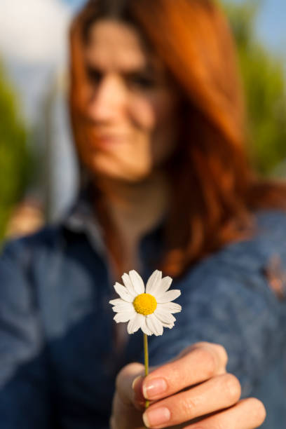 istock Young Woman Extending Her Daisy 1270971326