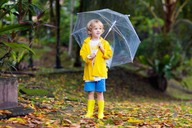 istock Child playing in autumn rain. Kid with umbrella. 1270971501