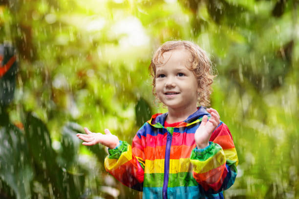 istock Child playing in the rain. Kid with umbrella. 1270971583