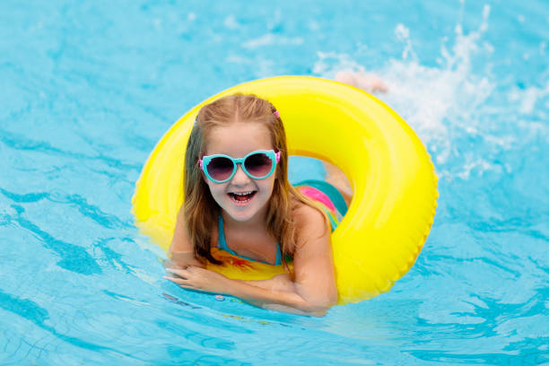 bambino in piscina sull'anello giocattolo. i bambini nuotano. - inflatable ring water wings swimming pool float foto e immagini stock