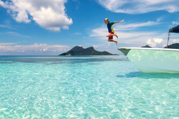niño saltando al agua de mar. vacaciones en yate. - child jumping swimming nautical vessel fotografías e imágenes de stock