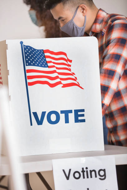 istock Voters placing their ballots.  Wearing face masks. 1270973512