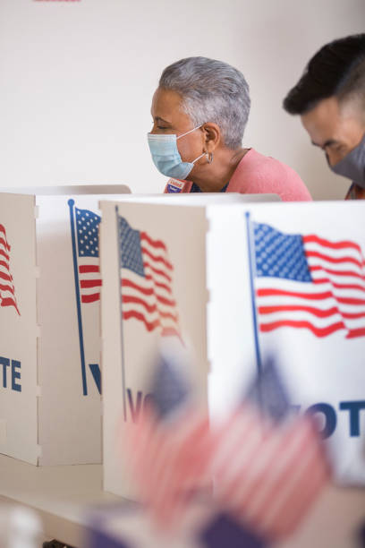 istock Voters placing their ballots.  Wearing face masks. 1270973521