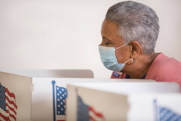 istock Voters placing their ballots.  Wearing face masks. 1270973523