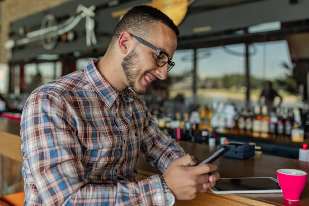 istock Young Man Checking Mobile Phone In Coffee Shop 1270979180