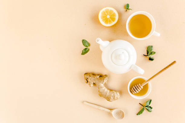 istock Herbal tea with mint, ginger, lemon, honey and other herbs on yellow background. Flat lay, top view 1270980238