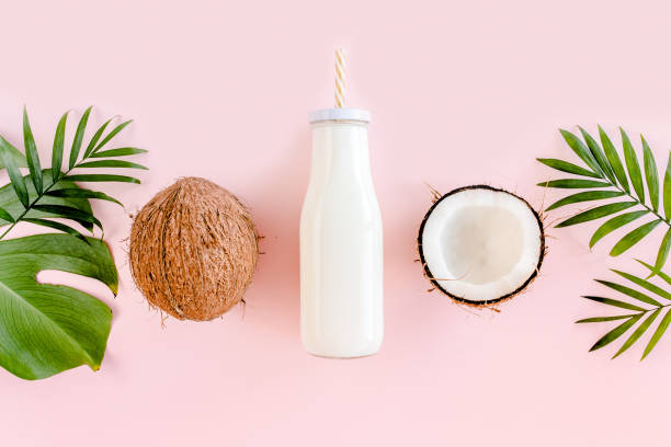 Pattern with coconuts and tropical palm leaves on pink background. Tropical abstract background. Flat lay, top view