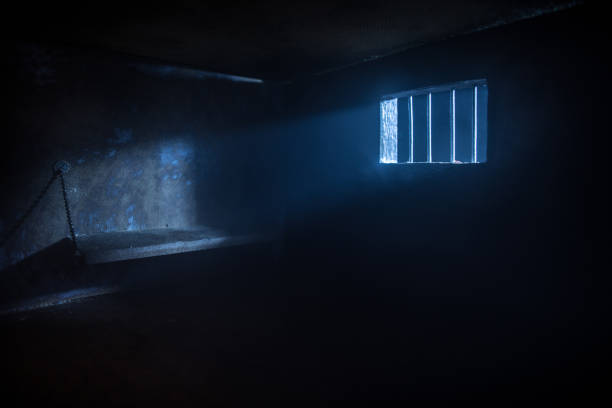 Behind bars concept. Obsolete grunge concrete room miniature. Dark prison interior creative decoration. Empty cell. Selective focus