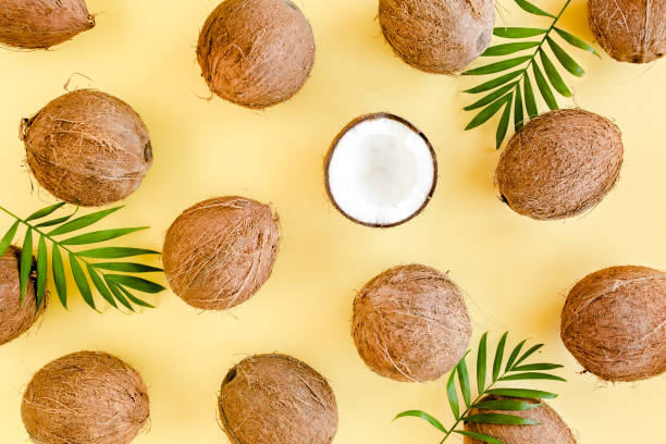 istock Pattern with coconuts and tropical palm leaves on yellow background. Tropical abstract background. Flat lay, top view 1270985327
