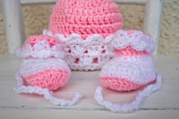 istock Pink and white baby knitted cap and slippers 1270985589