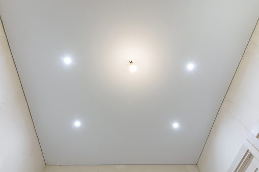 Matte vinyl stretch ceiling in the interior of the room, spotlights included