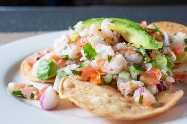 plate of shrimp tostada A closeup view of a plate of shrimp tostada, in a restaurant or kitchen setting. seviche photos stock pictures, royalty-free photos & images