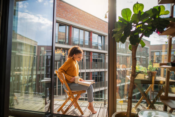 istock Young woman reading a book at home 1270988402