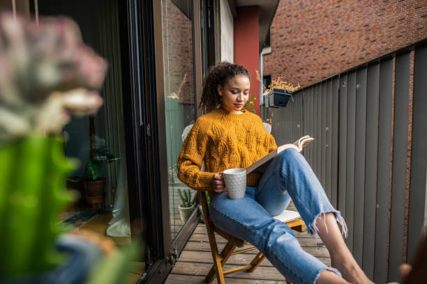Young woman reading a book at home stock photo