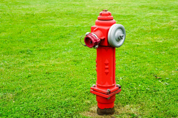 bright red isolated fire hydrant sits in a freshly cut grass field