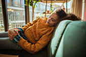 Woman is resting on the sofa in her apartment